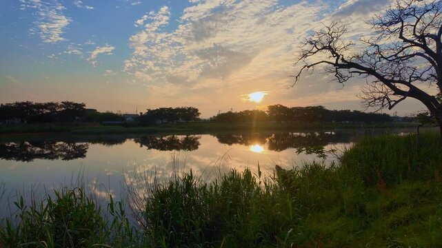川に昇る太陽。水面に太陽の光が差し込む。揺れる&ldquo;みなも&rdquo;の雲01