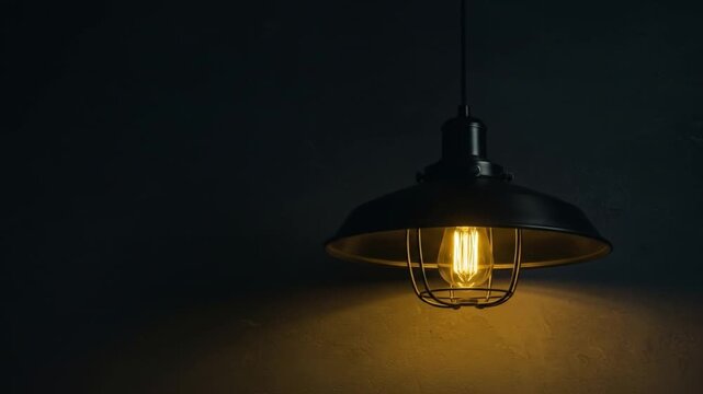 Illuminated bulb in a vintagestyle black metal lamp casts warm light against a dark textured wall