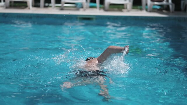 Authentic Man Swimming Crawl Stroke in Blue Pool Summer Recreation