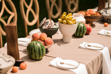 Luxury tropical banquet detail with gourmet fruit artisan cookies and contemporary neutral wedding table styling outdoors © Nele