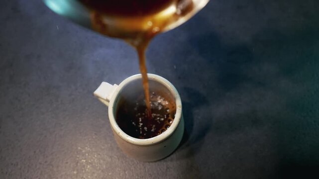 Steaming Black Coffee Poured Into Mug on Dark Countertop