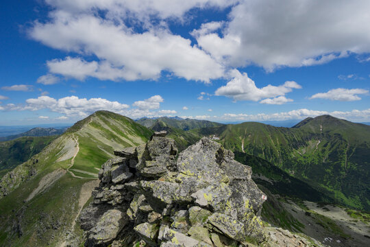 View of Tri kopy in Western Tatras with sharp rocky peaks and green mountain slopes under a blue sky with white clouds in Ziar, Zilina Region, Slovakia.
