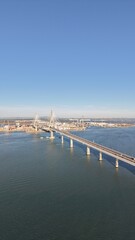 Aerial view of the Constitution of 1812 Bridge in Cadiz, Spain. Cinematic drone shot of the modern landmark cable-stayed bridge over the bay on a sunny day