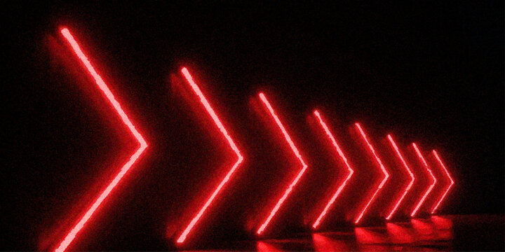 Perspective view of red neon arrow lights forming a glowing tunnel path on dark background