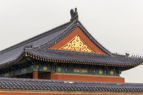 View of the ornate blue tiled roof of a traditional Chinese temple with golden decorative patterns and intricate carvings in Beijing, Beijing, China.