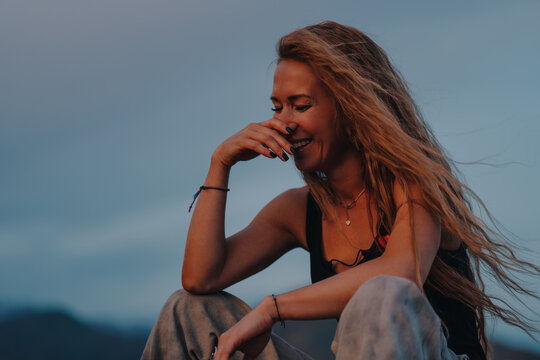 Laughing woman portrait at sunset over mountain