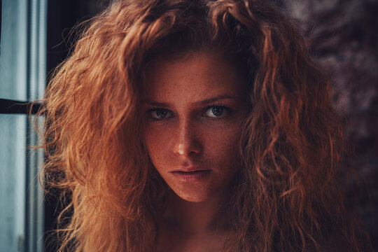 Portrait of a beautiful young woman with red hair and freckles