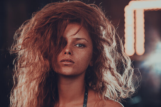 Beauty portrait of ginger woman with freckles and messy red hair