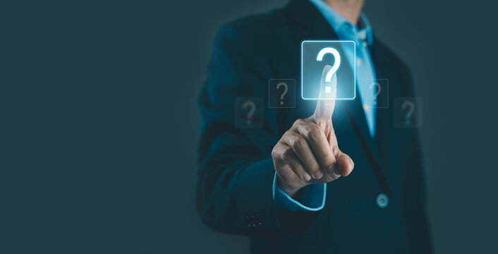 Businessman touching glowing question mark icon on virtual screen, symbolizing FAQ, problem solving, decision making, support, and business uncertainty. Modern technology interface with copy space.