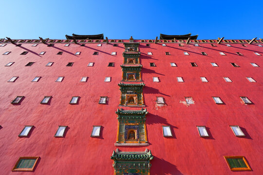 Symmetrical low-angle view of the monumental red facade of the Great Red Terrace at Putuo Zongcheng Temple, Chengde, Hebei, China