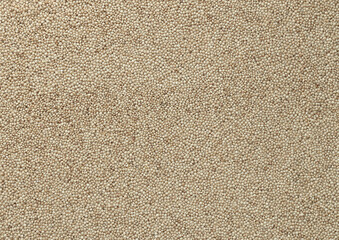 Fototapeta premium Dry amaranth grains in big pile on table close up. Large amount of yellow amaranth grains