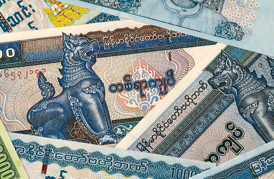 Myanmar kyat money bills in pile on table. Myanmar MMK currency cash close up
