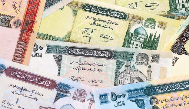 Afghan afghani money bills in pile on table. Afghanistan AFN currency cash close up