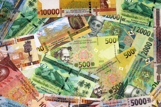 Guinean franc money bills in pile on table. Guinea GNF currency cash close up