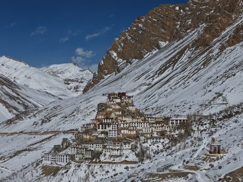 Kaza, India - 28 January 2026: View of Key Monastery nestled against snow-capped Himalayan peaks in the Spiti Valley under a clear blue sky.