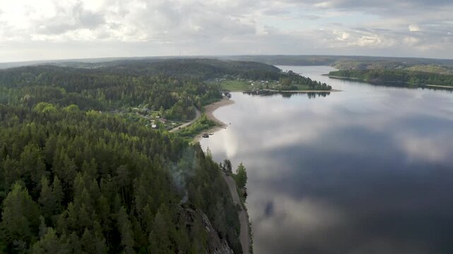 Rising up aerial shot above Zmeinaya Gora (Snake Mount) and Yakimvarsky gulf of Ladoga lake on summer evening. Sorola village, Karelia, Russia.