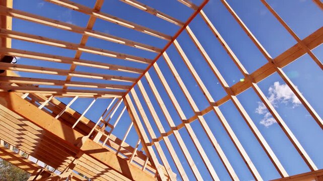 Workers build wooden roof frame with beams trusses as roofing framing