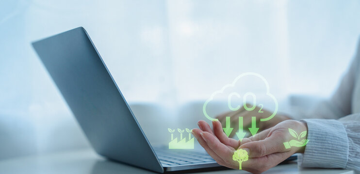 Person using laptop with eco friendly icons representing carbon reduction and sustainability