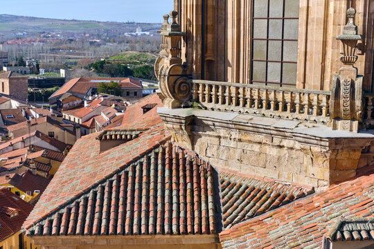 Salamanca, Spain - 01 December 2025: View of the Pontifical University of Salamanca featuring ornate stone carvings and a balcony overlooking the historic terracotta rooftops of the city.