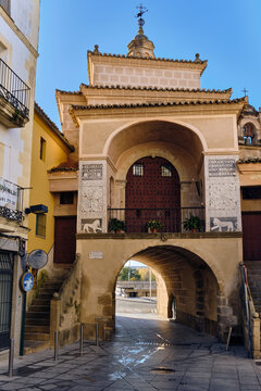 Plasencia, Spain - 03 December 2025: View of the historic Puerta de Trujillo gate and the Ermita de la Salud chapel with its ornate stone facade and bell tower.