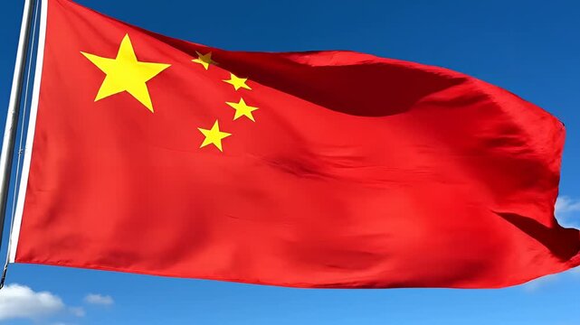 The vibrant red flag of China waves proudly against a clear blue sky.