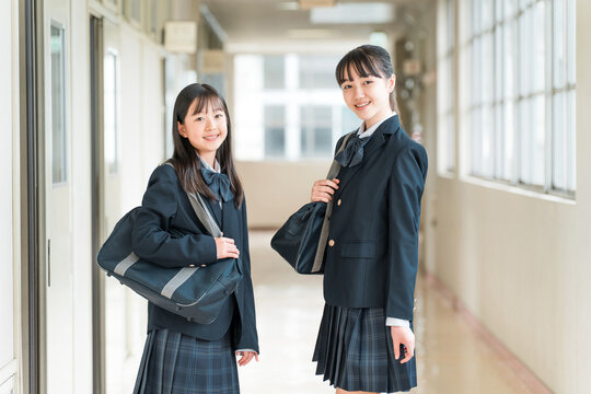 学校の廊下にいる制服姿の女子中学生,女子高生