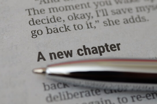 A new chapter text on book page with silver pen macro shot for business concept