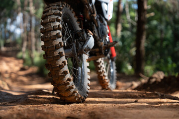 Off road motorcycle on dirt trail in forest, showcasing rugged tires and adventure © PIPAT