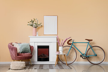 Fototapeta premium Interior of living room with fireplace, bicycle, armchair and blooming branches in vases