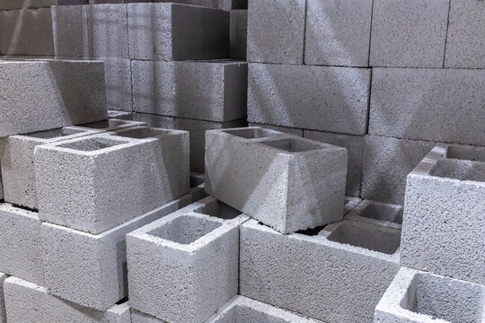 Stacks of grey concrete cinder blocks and hollow core masonry units organized inside a building materials warehouse or hardware store, USA