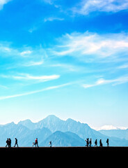 Obraz premium Silhouetted people walking and relaxing on street over sunny morning sky with high mountains in Antalya, Turkey