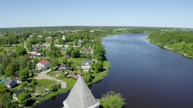 Backward reveal aerial shot of Ladoga fortress and Volkhov river on sunny day. Staraya Ladoga, Leningrad Oblast, Russia.