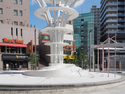 TOKYO, JAPAN - October 15, 2024: Monument in the center of the ironowa hiro ba plaza in Otsuka. There is a Royal Host restaurnat, a Pronto coffee shop, a hotel and other businesses behind it.