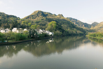 Obraz premium The mountains beside the river are shrouded in mist.