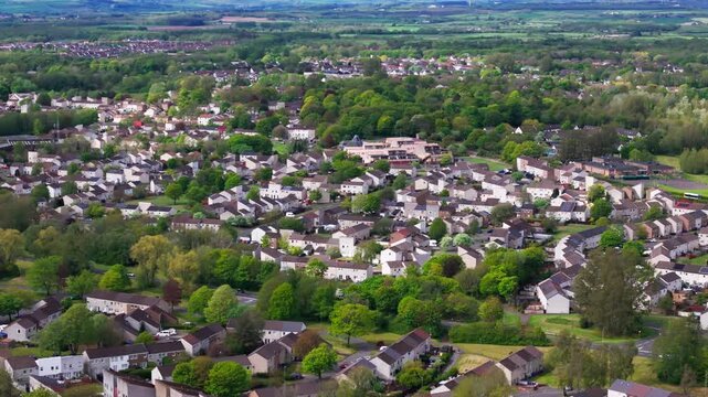 Residential housing estate of Bourtreehill village in Irvine, Ayrshire, showcasing green suburban neighborhoods and town layout, cinematic aerial view