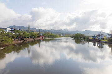Obraz premium The mountains beside the river are shrouded in mist.
