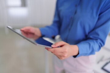 business professional person holding digital tablet device browsing internet reading data report checking information technology at modern office workplace © Audtakorn