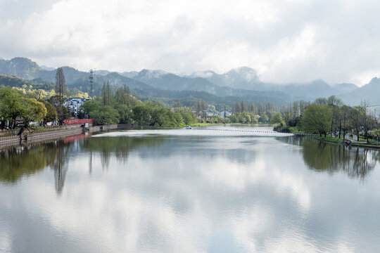 The mountains beside the river are shrouded in mist.