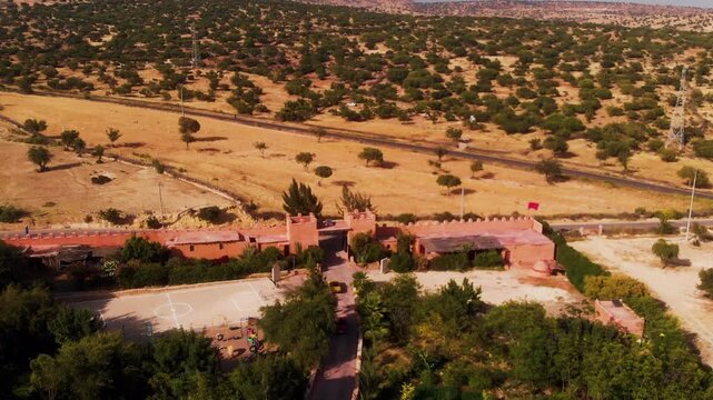 Drone view of a Moroccan kasbah style compound in an arid rural landscape