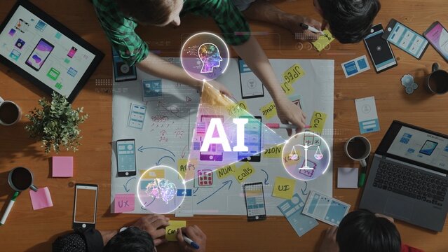 A creative team engages in a collaborative brainstorming session about artificial intelligence, using sticky notes and laptops to develop innovative ideas and strategies. Raster