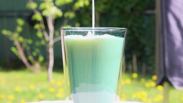 Video pouring milk into a glass, till the brink.
