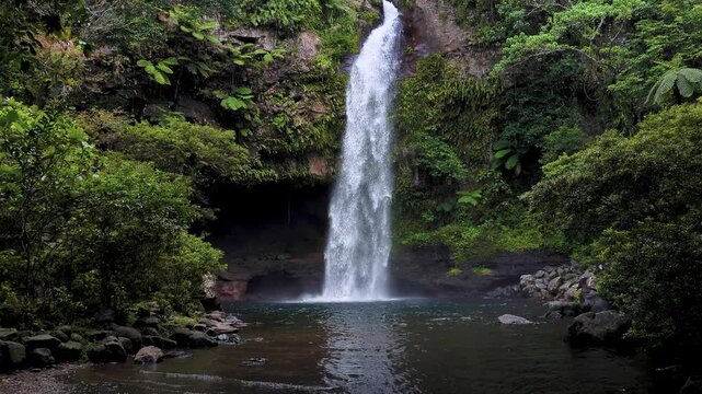 Pan down of Tavoro Waterfall and lush rugged forest landscape at Bouma National Heritage Park on Taveuni Island, Fiji in South Pacific