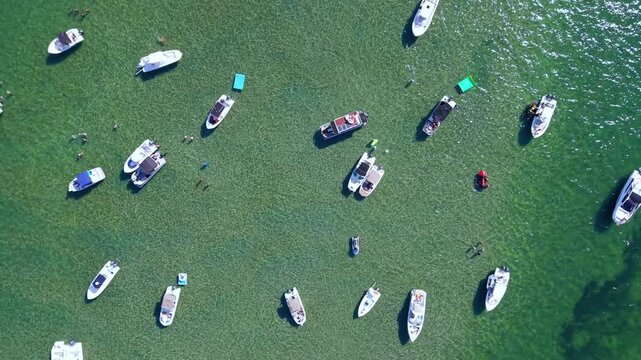 Straight down drone aerial shot of the Boca Raton sandbar in Florida on a clear day with boats and turquoise green water visible from above