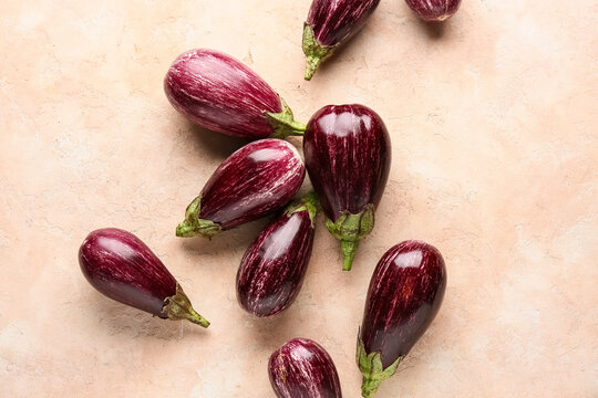 Fresh ripe eggplants on beige background