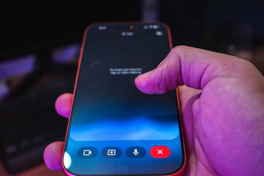 Voice command interaction with the Gemini virtual assistant on a cellphone screen under purple lighting.