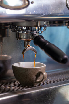 Close up of fresh espresso extraction into ceramic cup