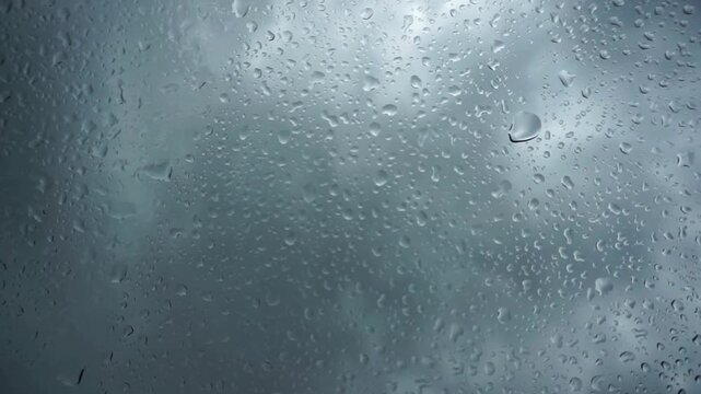 Clear rain droplets on a gloomy sky, suitable for weather forecasts, climate change articles, naturethemed designs, water cycle illustrations.