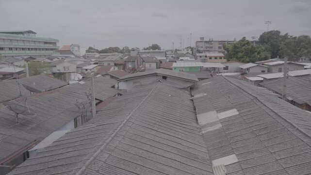 Rooftop View of Khlong Toei Slum Community in Bangkok - Ungraded LOG Footage. Rooftop view of overcrowded zinc and corrugated roofs within the Khlong Toei slum community in Bangkok, Thailand. Camera s