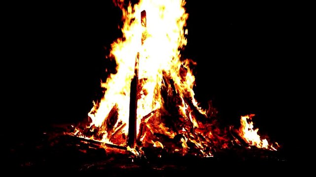 Orange flames on yellow wood in the dark, showcasing intensity and heat. Suitable for firerelated, night scene, or energy themes.