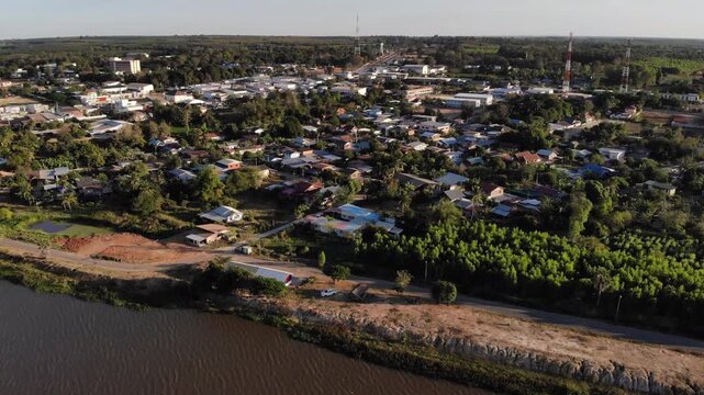 Aerial view of houses and lush vegetation surrounding a small rural town in northeastern of Thailand.
